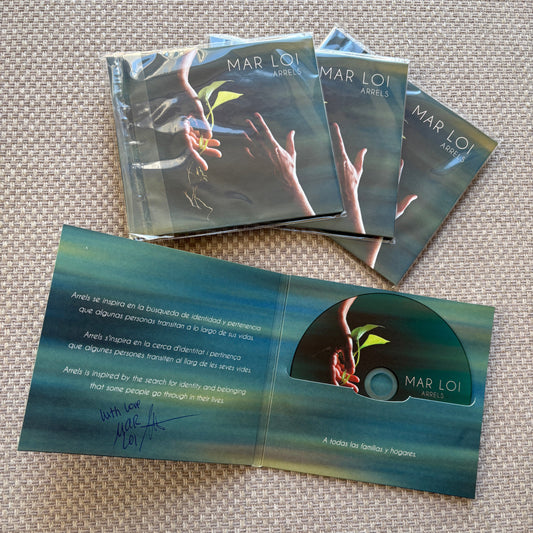 Three sealed copies of Mar Loi’s “Arrels” CD next to an open signed copy showing the disc and inner artwork.