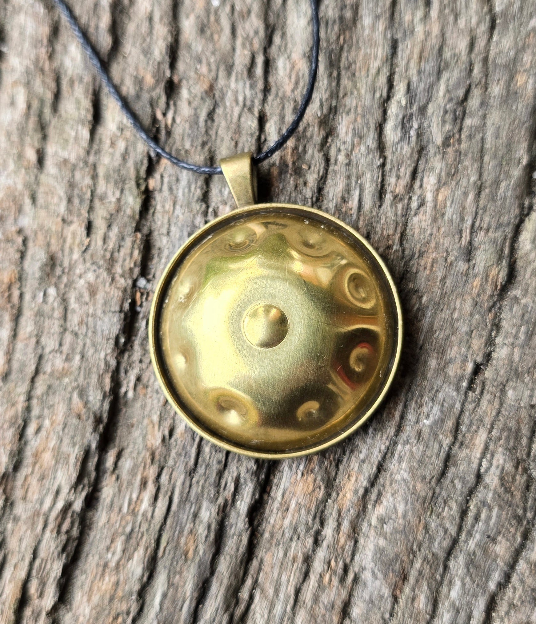 Brass Panshake pendant on rustic wooden background showing front dome detail.