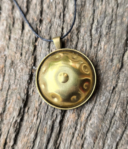 Brass Panshake pendant on rustic wooden background showing front dome detail.