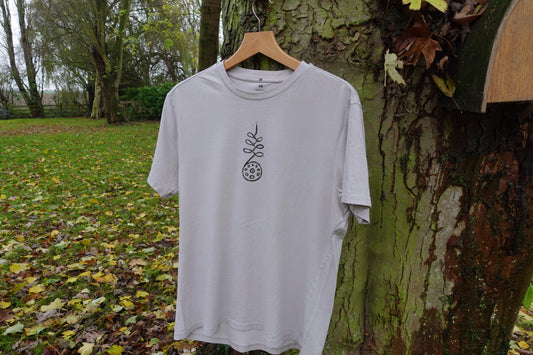 Front view of the light grey size M T-shirt outdoors with the hand-stamped artwork