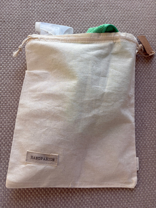 Beige fabric pouch with a label on a textured surface