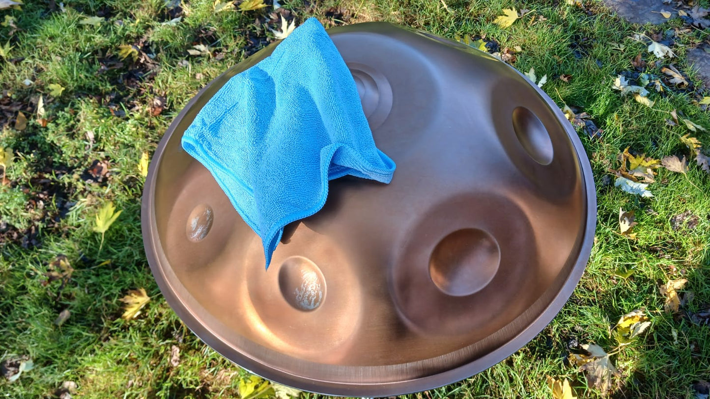 Handpan drum with a blue towel on a grassy background