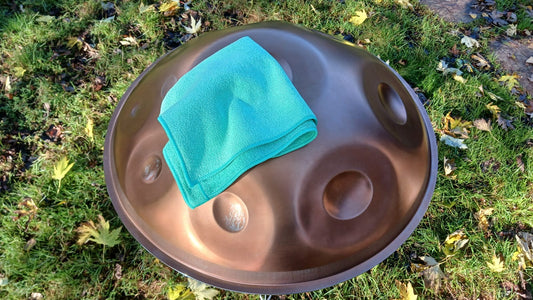 Copper handpan with a turquoise cloth on a grassy background