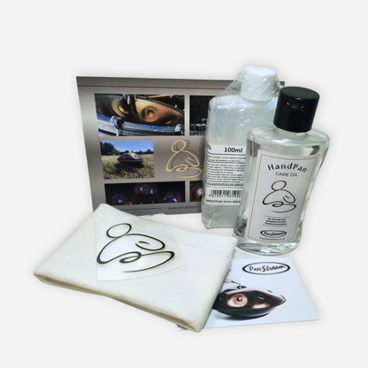 Hand pan care kit with two bottles, a cloth, and a leaflet on a white background