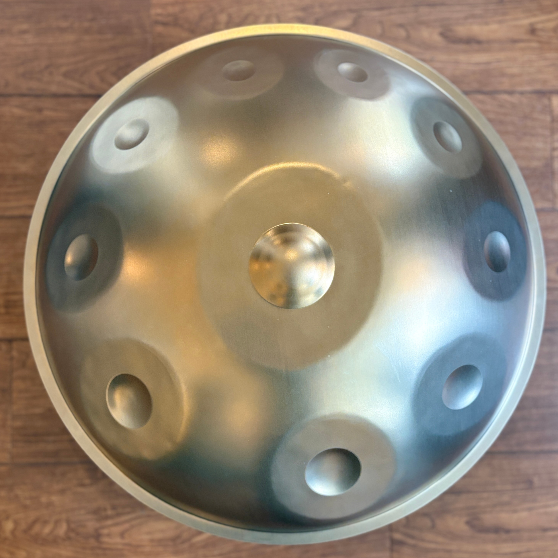 Metallic handpan on a wooden surface