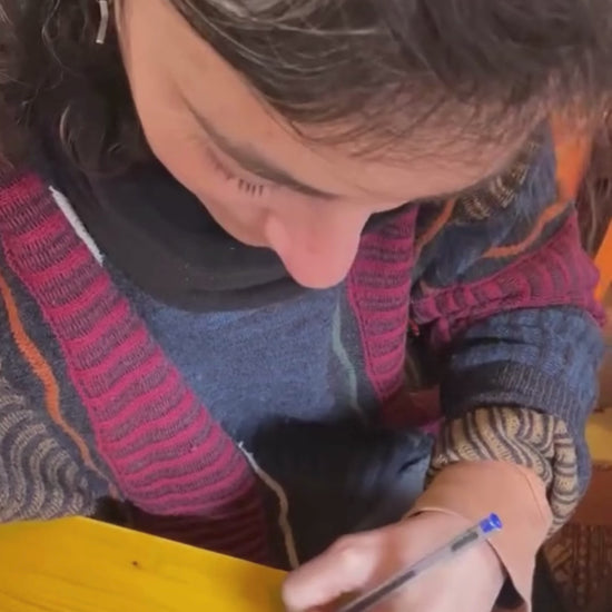 Mar Loi signing an “Arrels” CD and showing the finished signature.