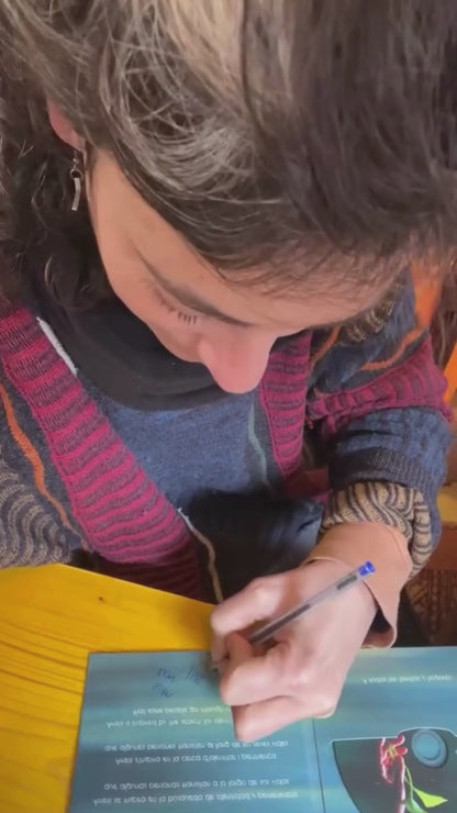 Mar Loi signing an “Arrels” CD and showing the finished signature.