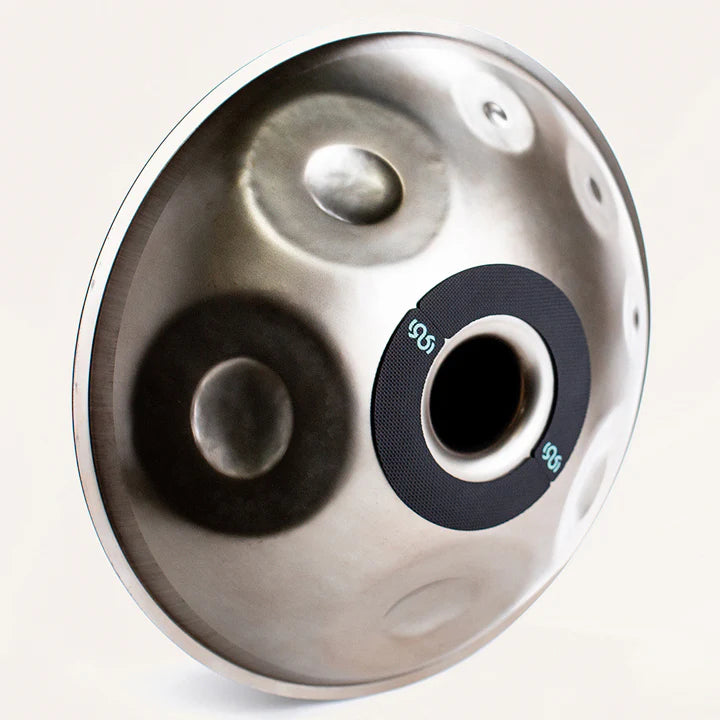 Handpan with Rhythm Rest magnetic grips attached around the gu on a white background