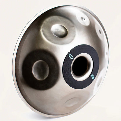 Handpan with Rhythm Rest magnetic grips attached around the gu on a white background